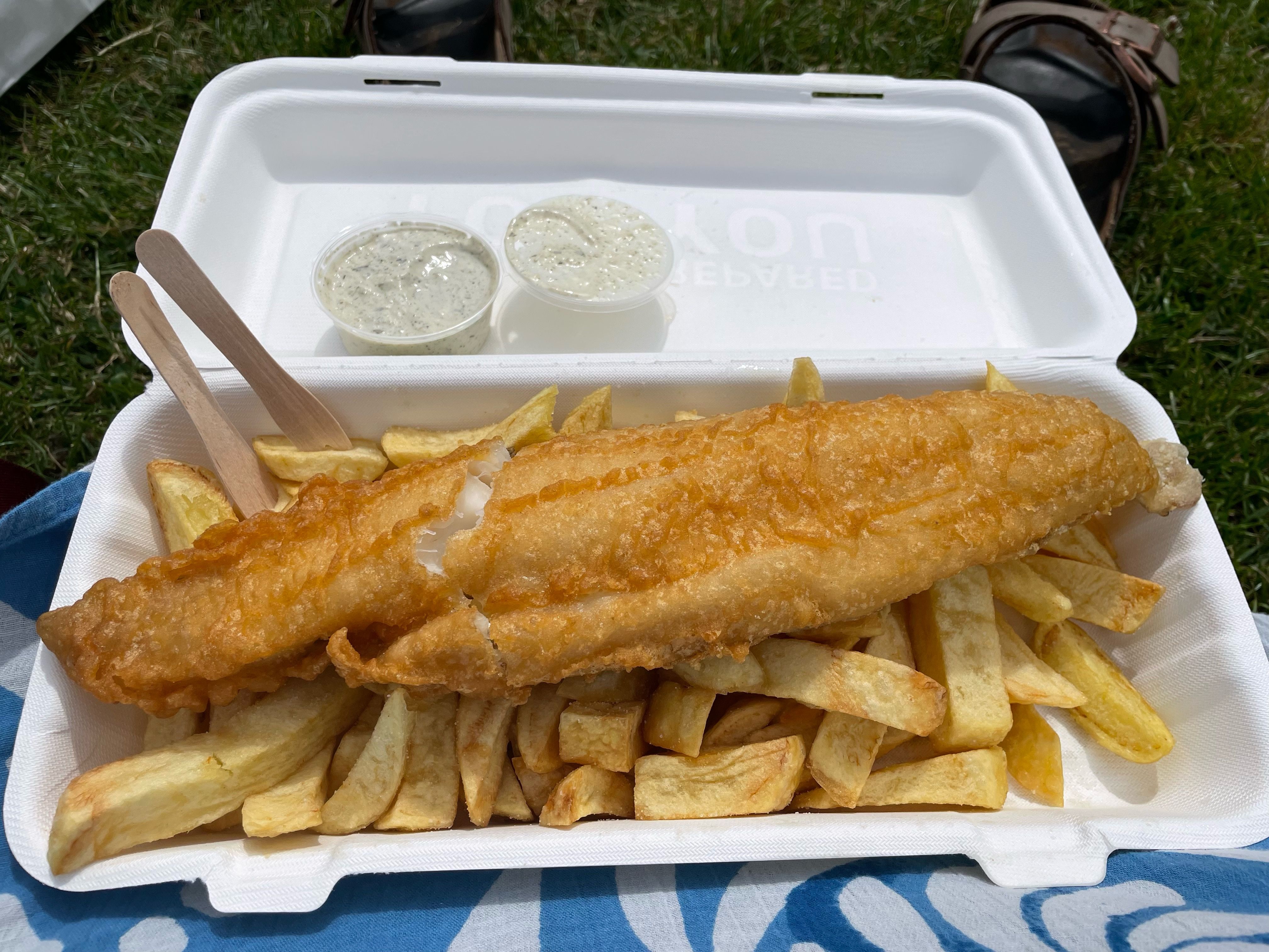 A takeaway box full of gluten-free fish and chips, with tartare sauce