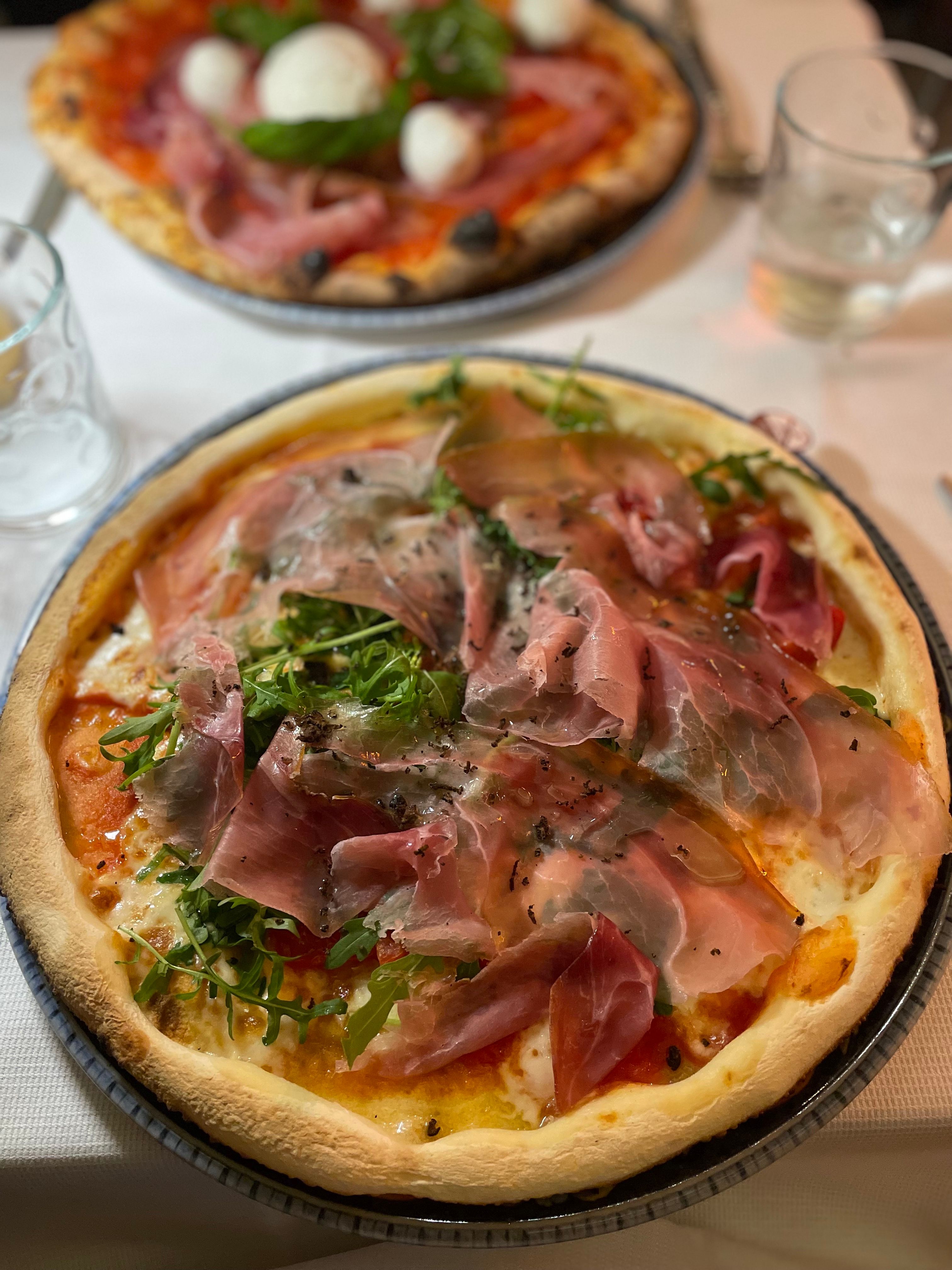 A gluten-free pizza topped with Tuscan ham, rocket, truffle and olive oil