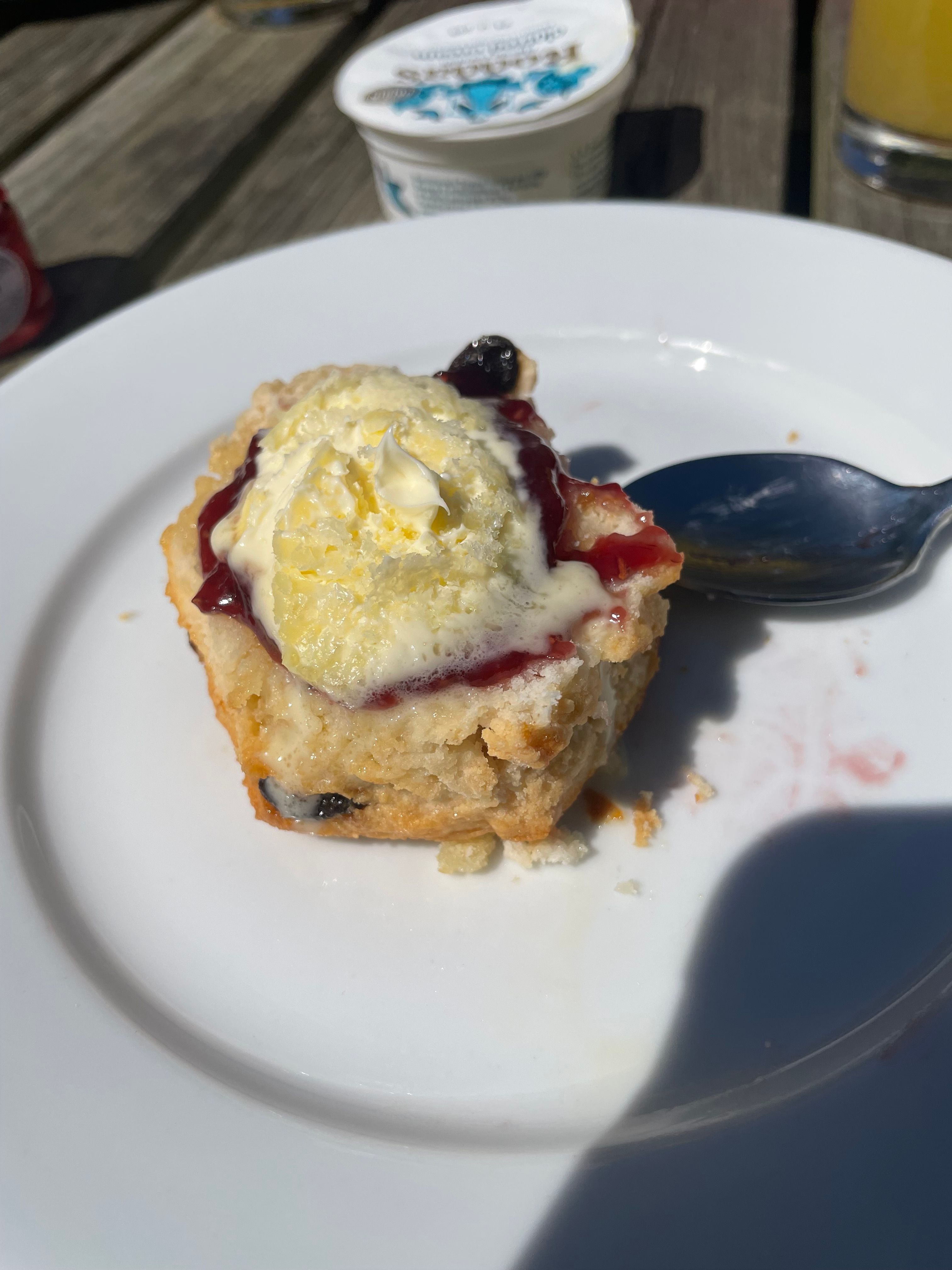 A fruity scone topped with jam and clotted cream